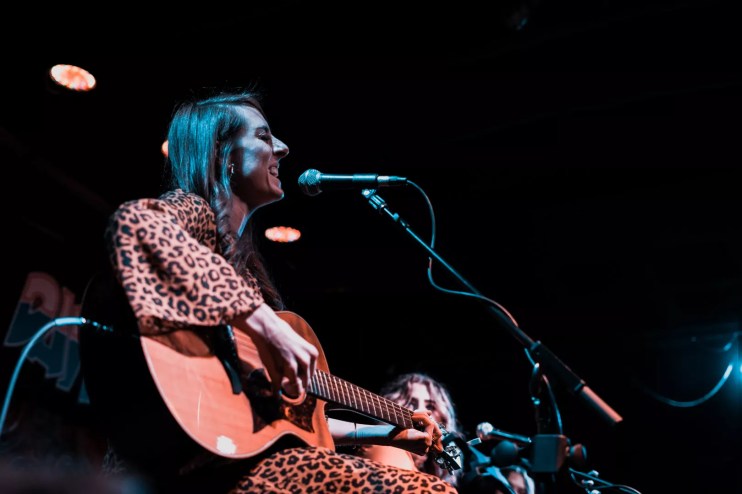 Dallas singer Sarah Johnson plays guitar onstage.