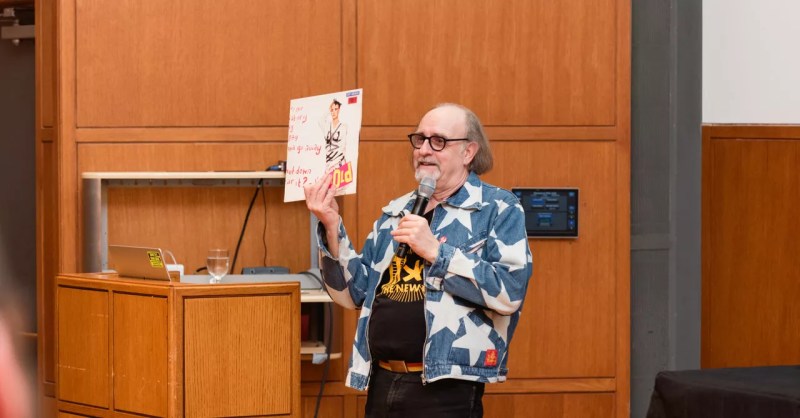 The legendary Malcolm Garrett, wearing a Vivienne Westwood design, speaking at the punk exhibition Torn Apart , currently on display in Dallas.
