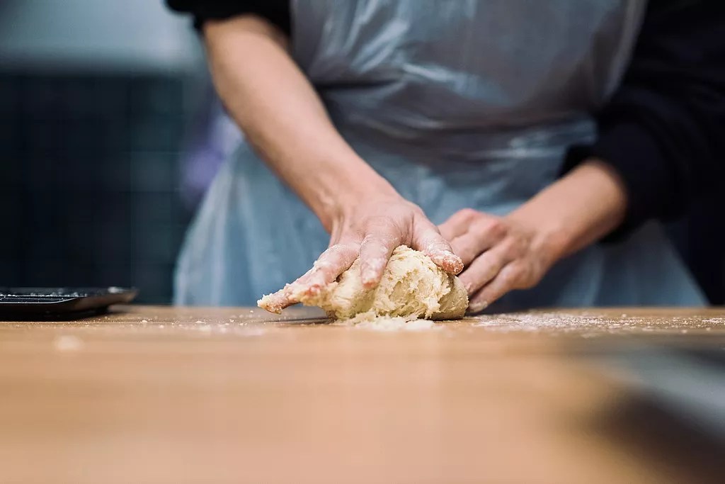a person rolling dough on a counter