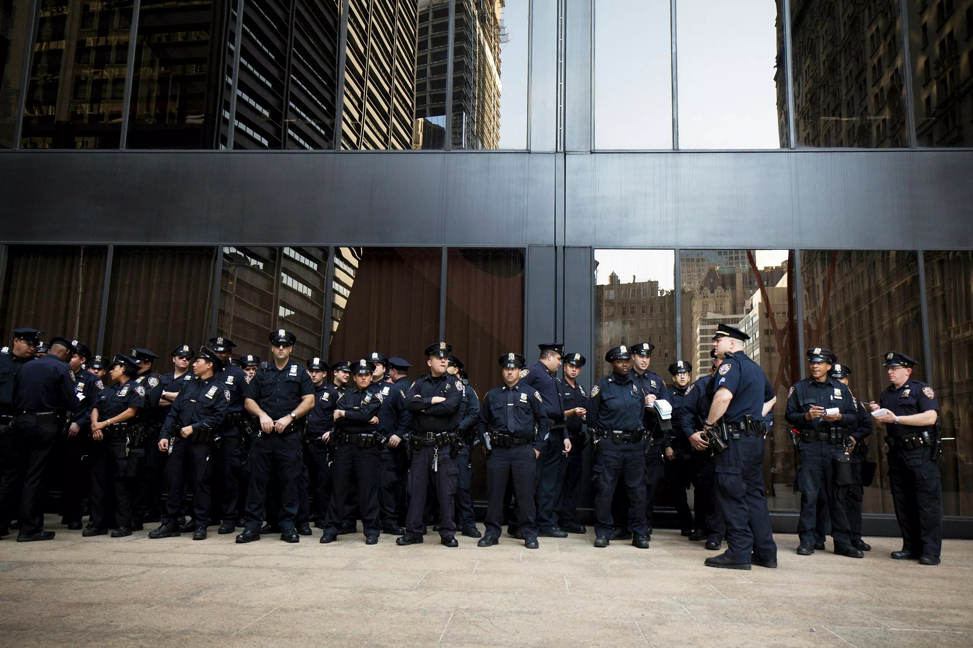 A large police force guards a downtown building.