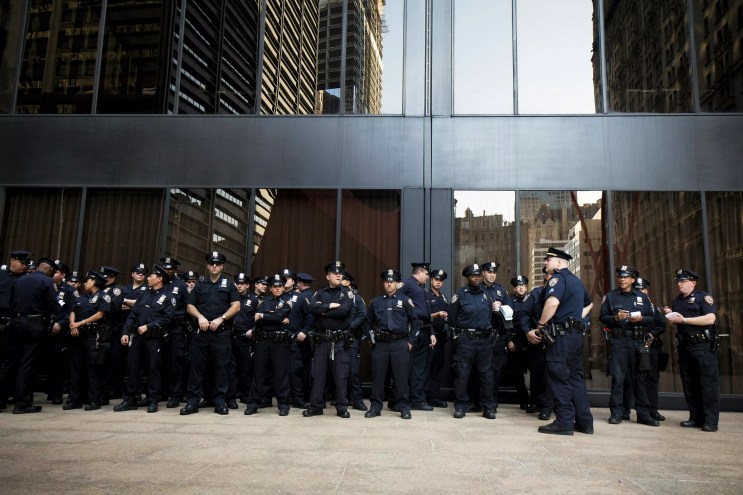 A large police force guards a downtown building.