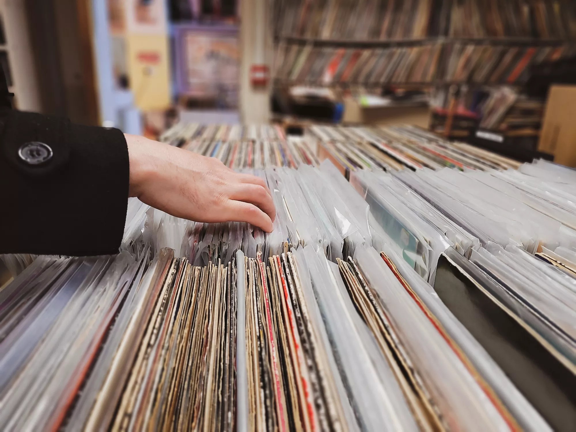 Woman flipping through vinyl records on sale.