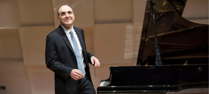 Dallas Symphony Orchestra's Dr. Richard Rogan near a piano.
