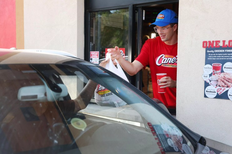 Team USA Olympic swimmer Nic Fink serves customers at a Raising Cane's in Dallas.