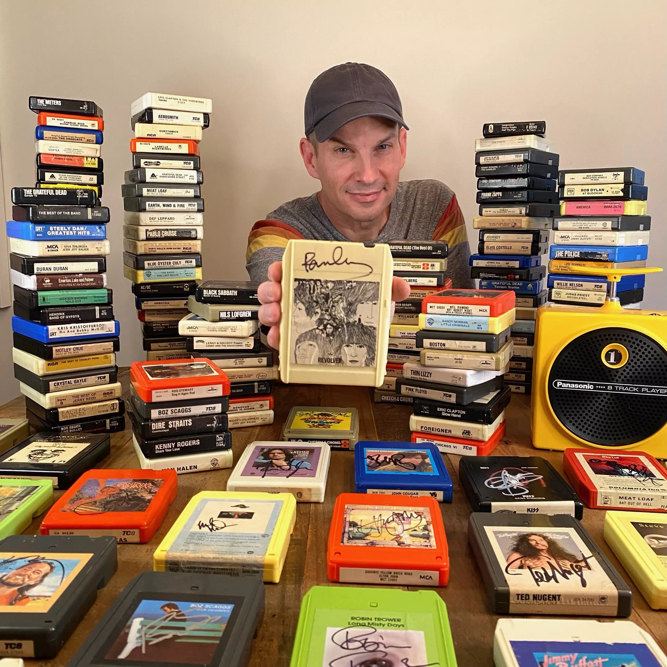 Jason Niebaum shows off his signed collection of 8-track tapes, which keeps growing one concert at a time.