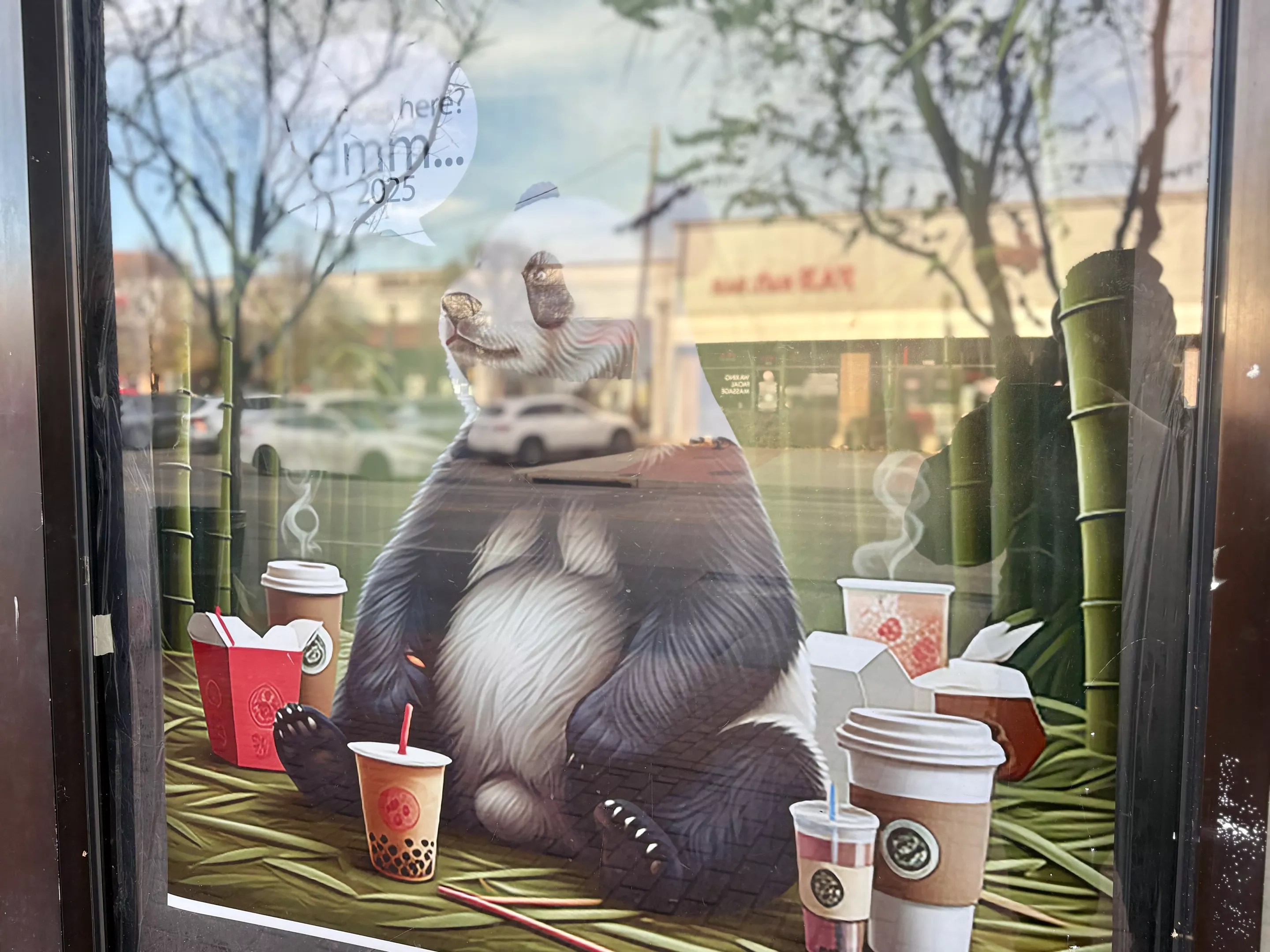 a panda bear poster in a restaurant window.