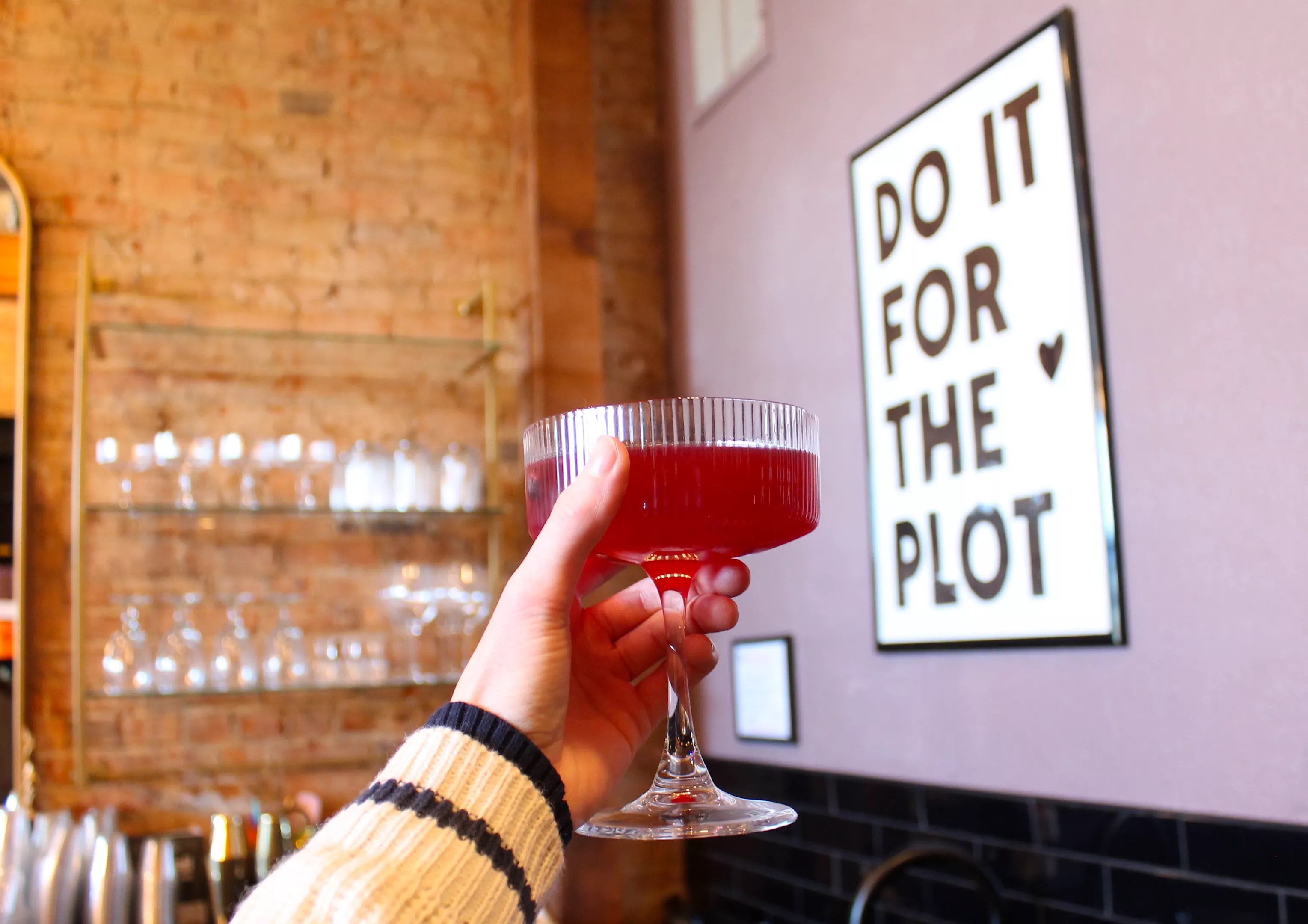 cocktail and sign at Plot Twist in Denton