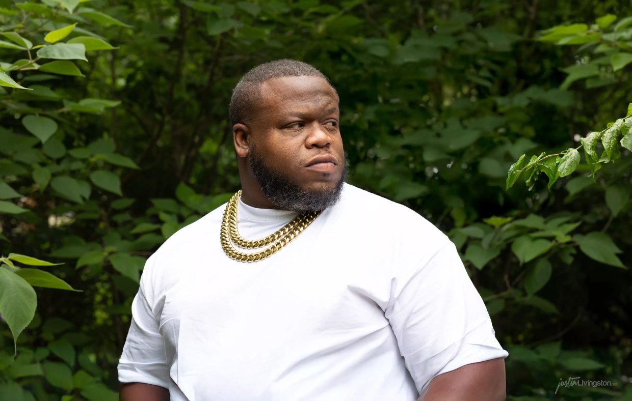 Man posing behind a tree