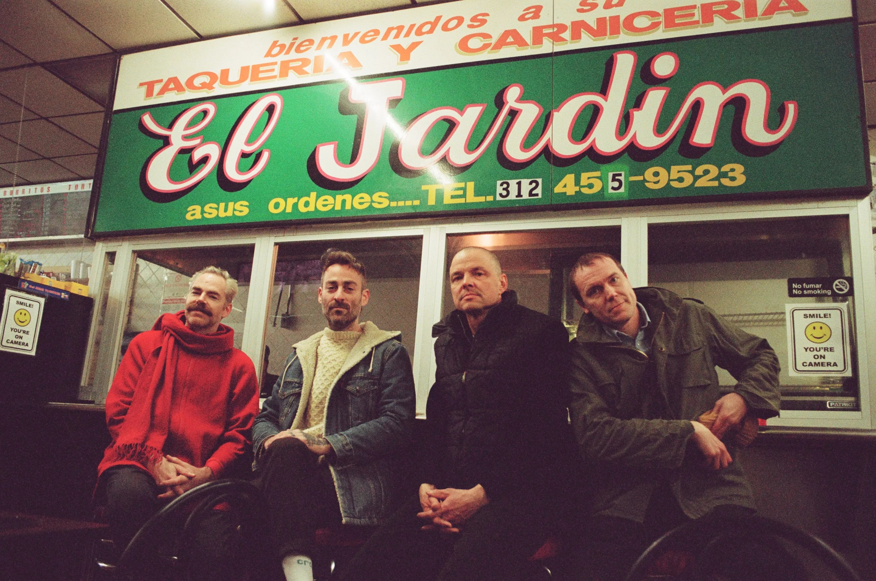 This is a photo of guys standing in front of a restaurant.