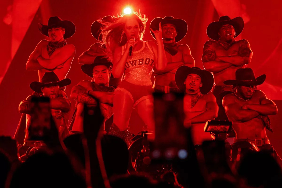 A woman performing on stage with dancers