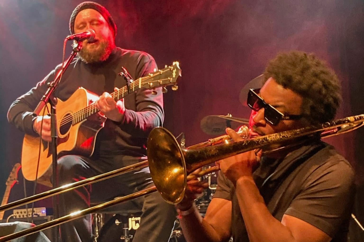 Man singing on stage with band members